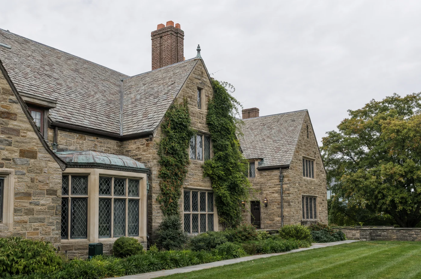 Beautifully restored historic Gold Coast stone manor with ivy accents and leaded glass windows